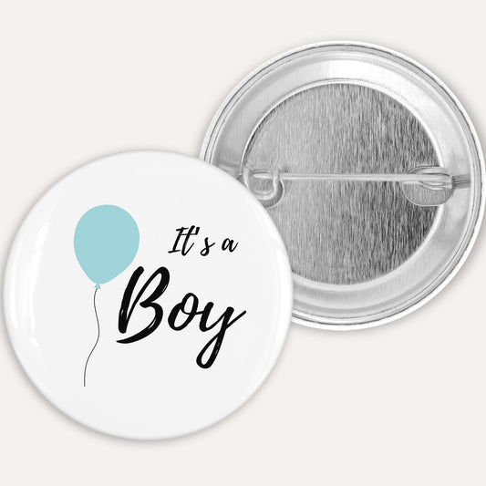 Button badge with 'It's a Boy' text and blue balloon graphic on a white background