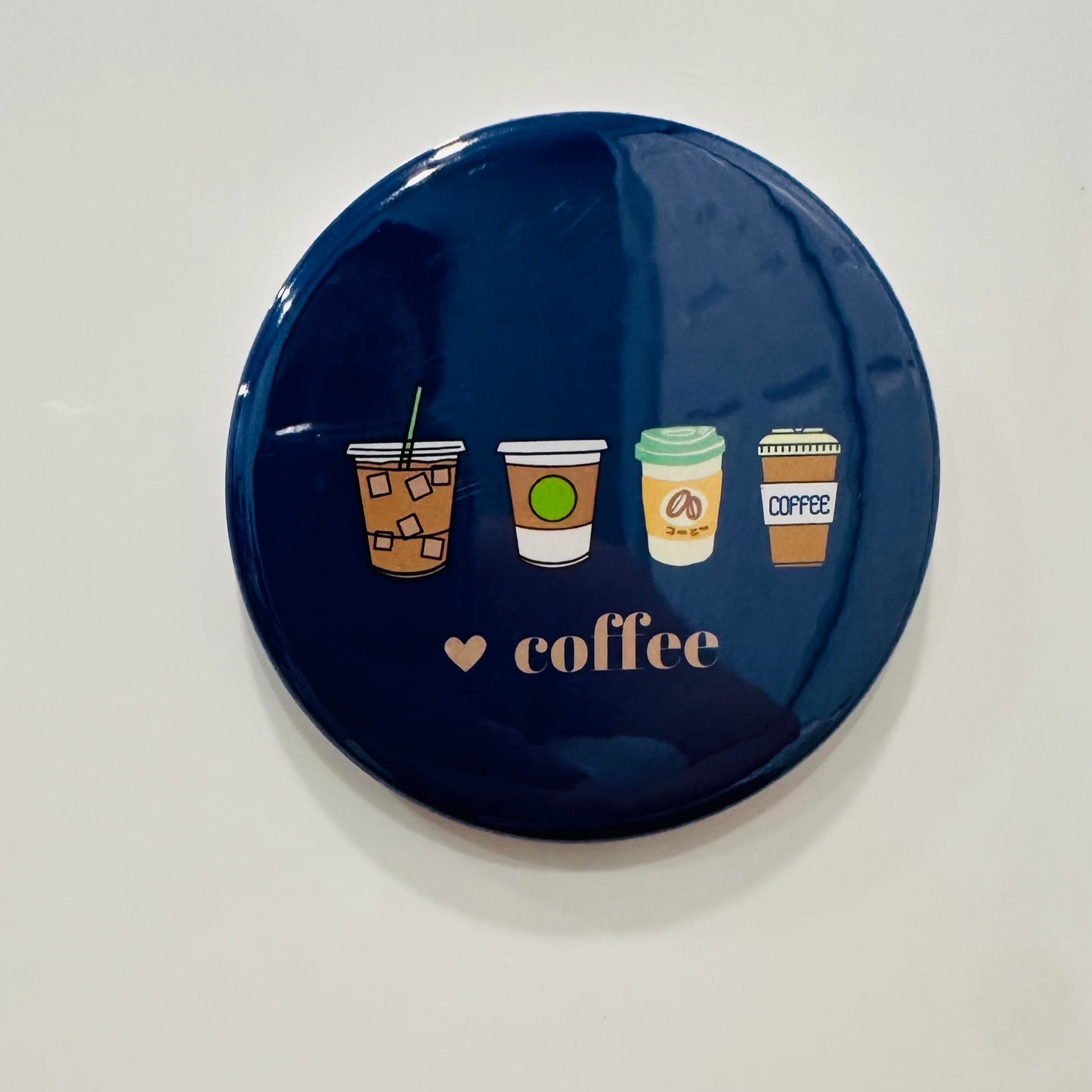 Navy blue fun round refrigerator magnet with coffee cup illustrations on a white background