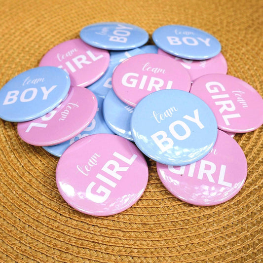 Pinback Buttons labeled 'team BOY' and 'team GIRL' on a textured surface